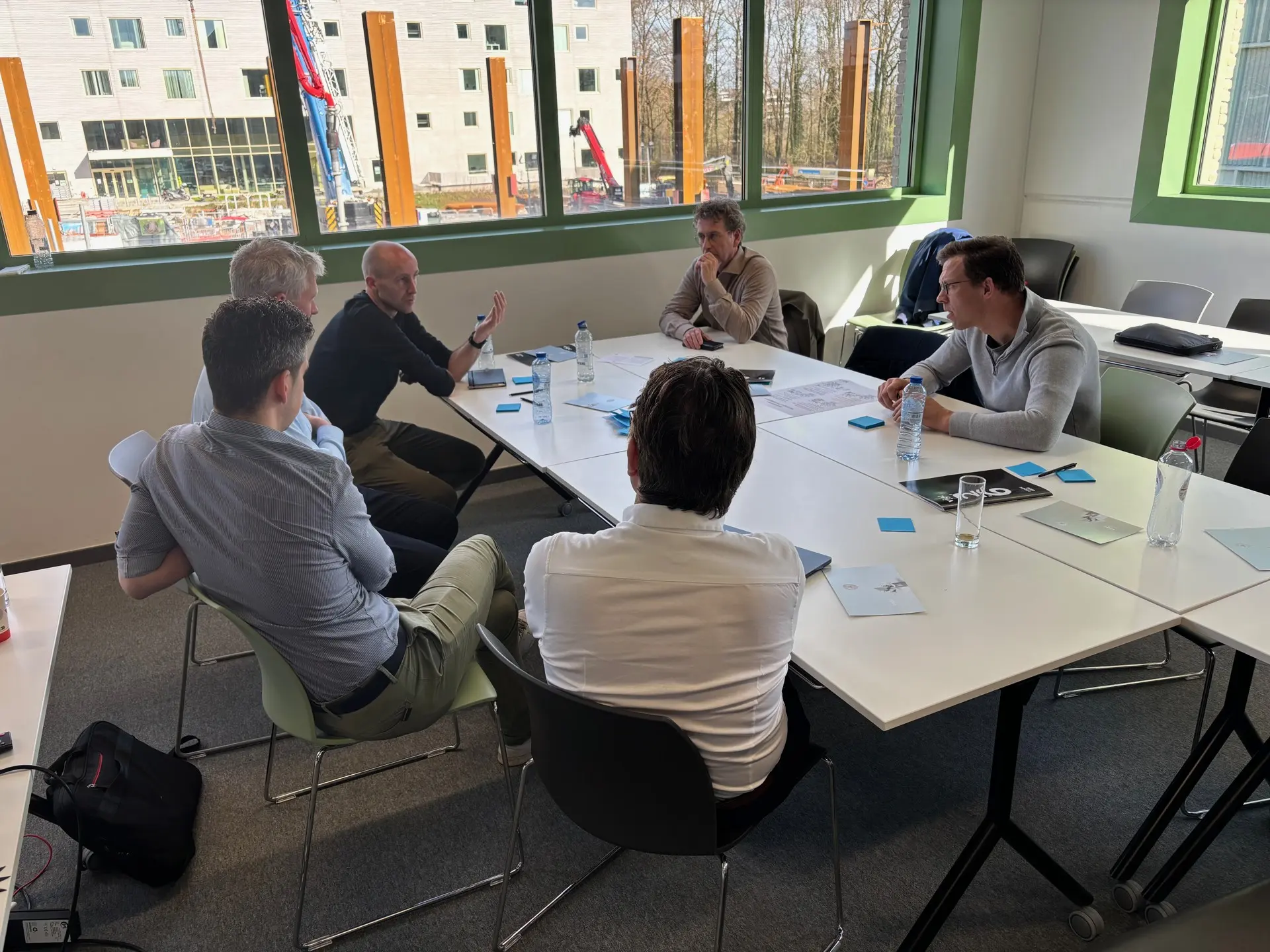 Deelnemers overleggen aan tafel tijdens de brainstorm